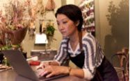 Woman at computer in florist type shop